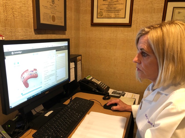 Dr. McKay studies the Invisalign scan to formulate the treatment plan that will give her patient’s the smile they always wanted